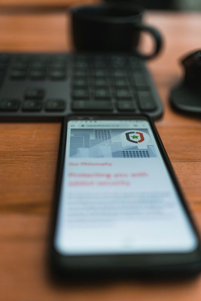 smartphone on a table next to the keyboard and a cup of coffee